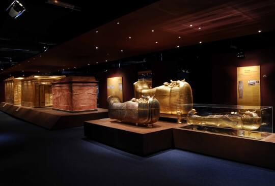 Various Egyptian caskets on display in an exhibit